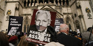 Mehrere Menschen halten Protestplakate in den Luft vor einem britischen Gericht